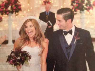 Tim Belusko and Danielle Fishel are walking down the aisle holding hands.
